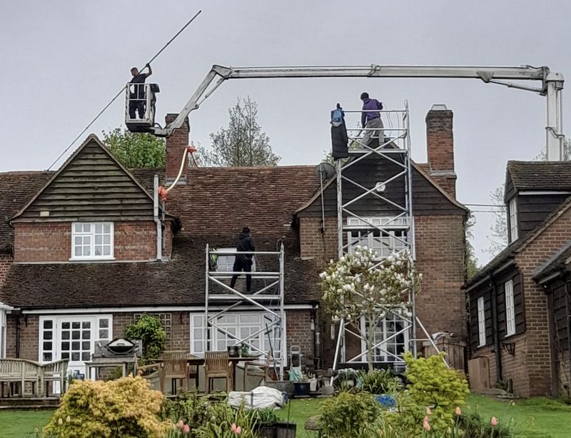 The Moss Cleaners using cherry picker and scaffolding to clean roof safely and professionally in Bishop's Cleeve, Gloucestershire